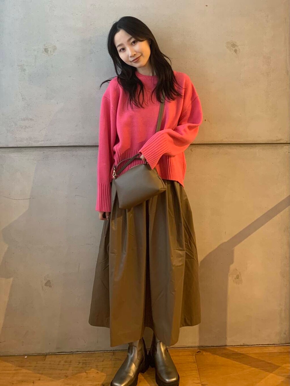 シルバー系のブーツ、ブラウン系のスカート、ピンク系のニット/セーターを着用したレディースの秋コーディネートの3枚目の写真