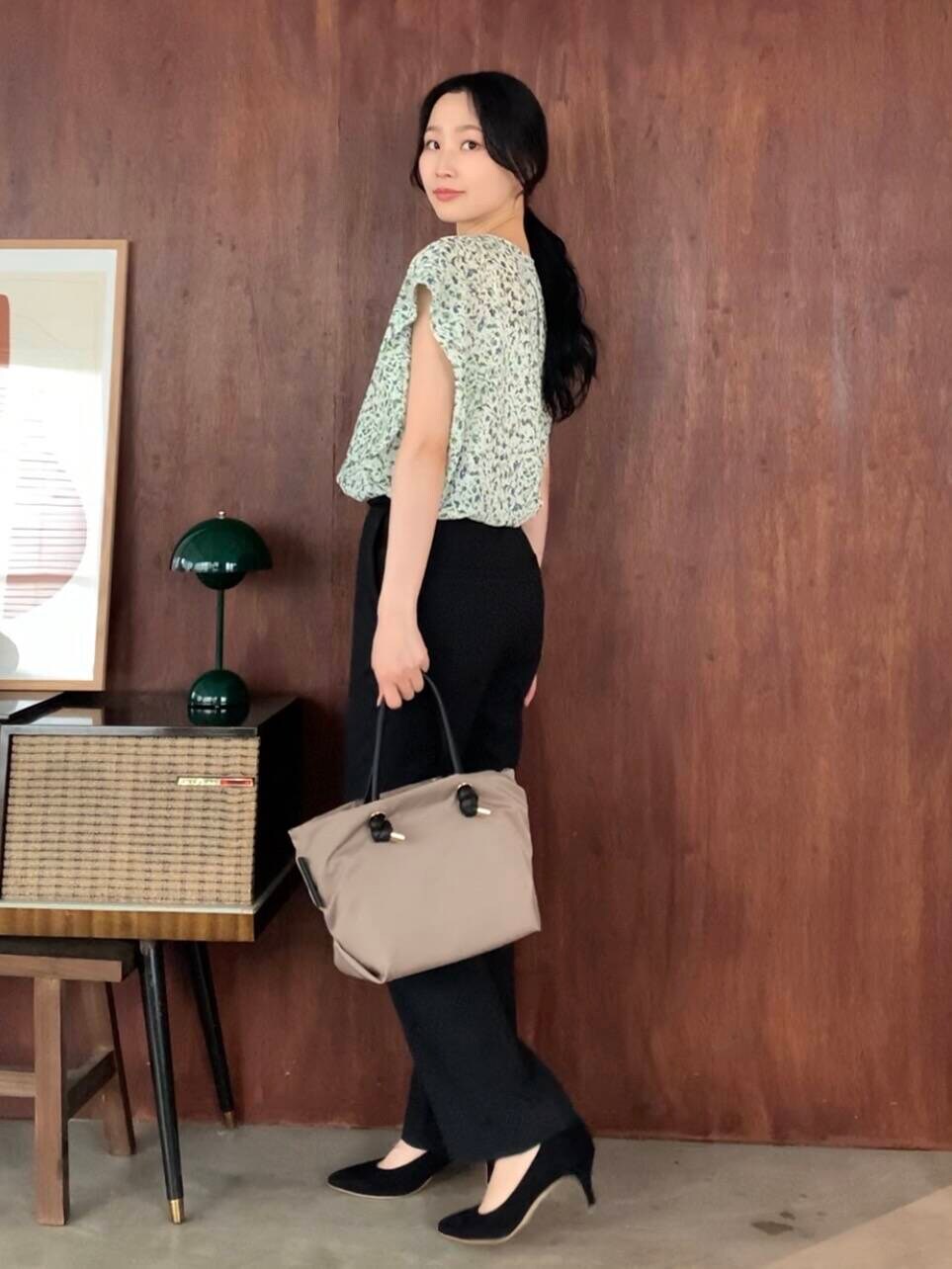 ブラック系のパンプス、ベージュ系のトートバッグ、ホワイト系のシャツ/ブラウスを着用したレディースの夏コーディネートの2枚目の写真