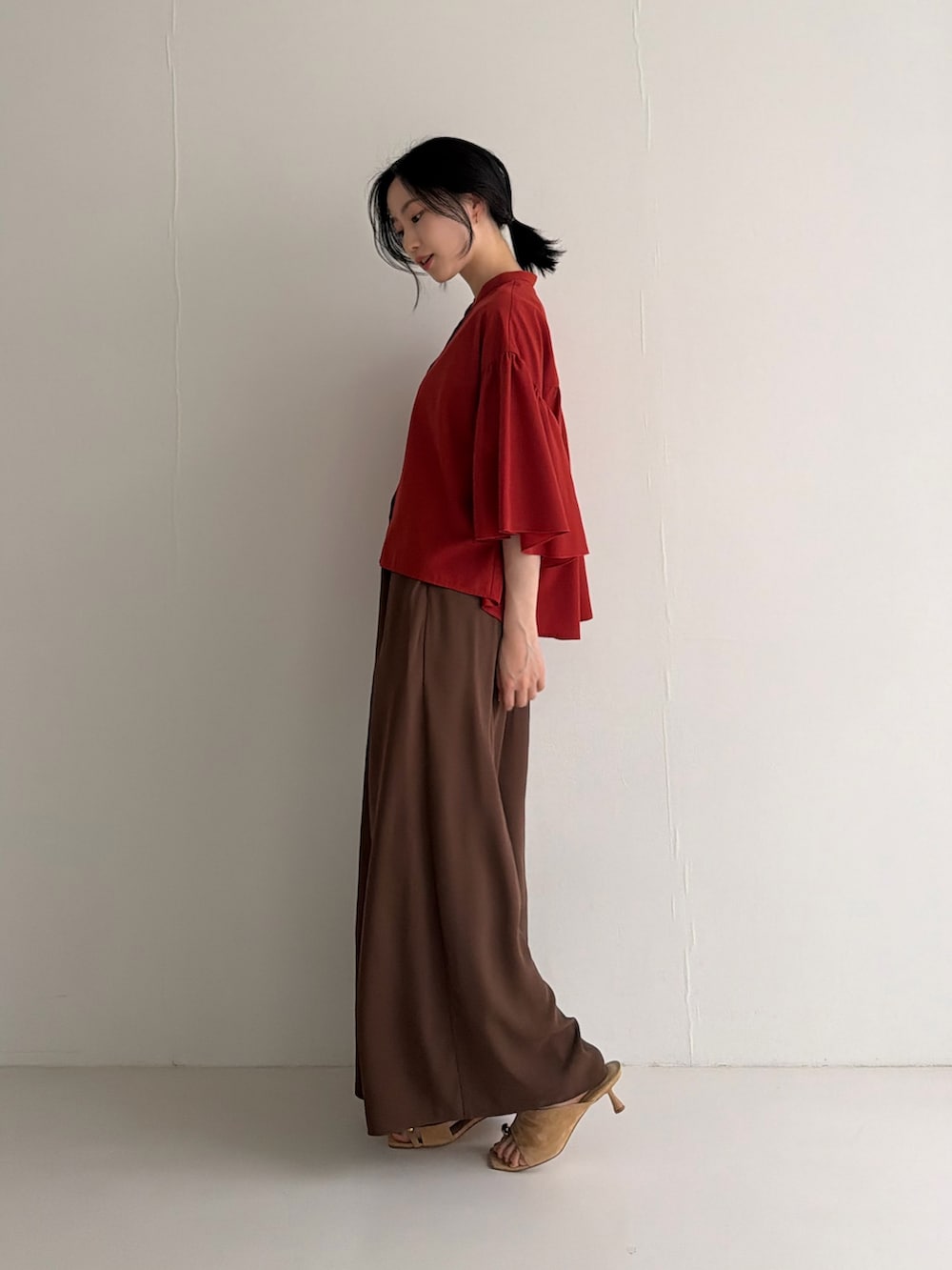 レッド系のシャツ/ブラウス、ブラウン系のその他パンツ、ブラウン系のパンプスを着用したレディースの春コーディネートの3枚目の写真