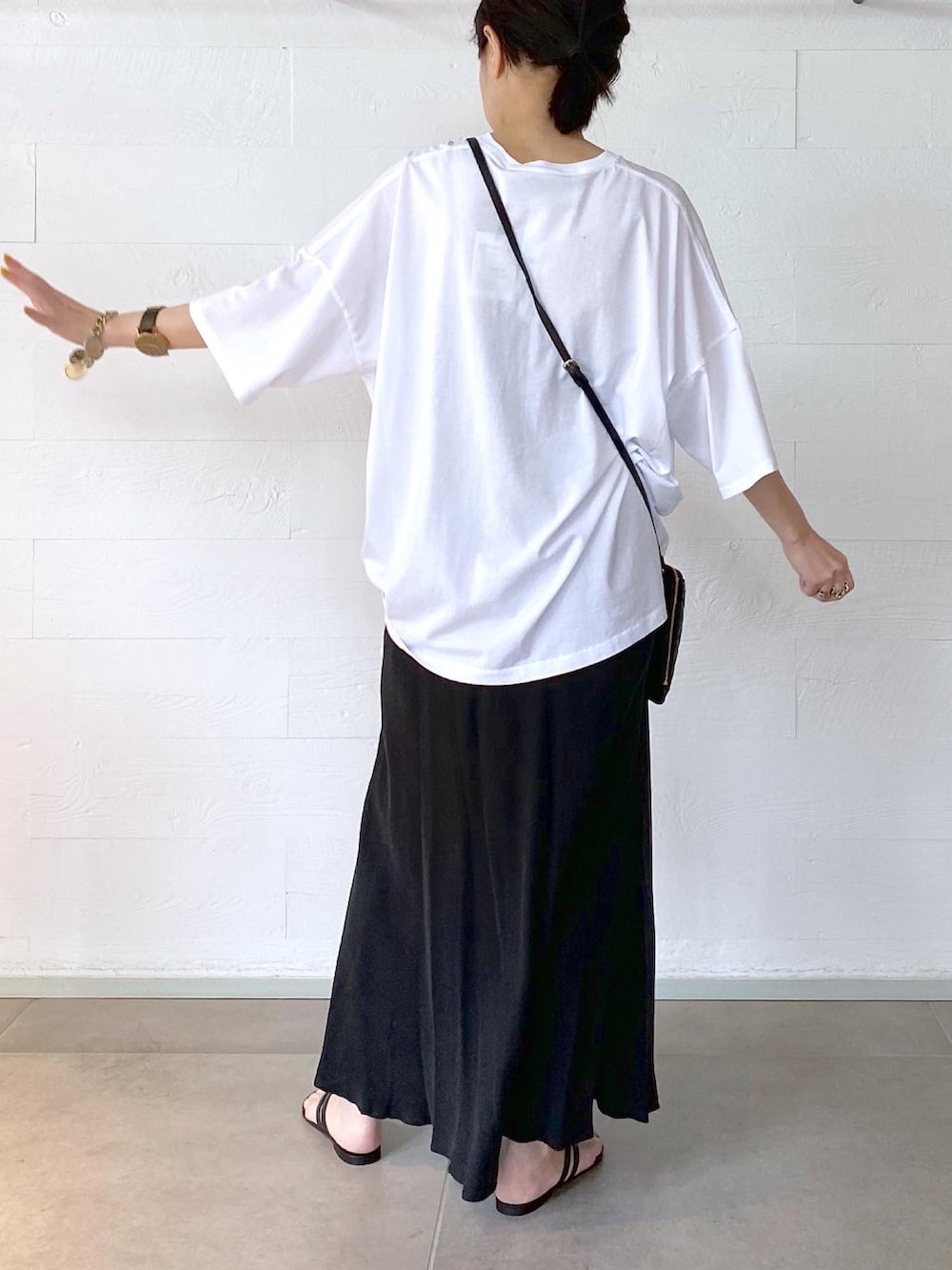 ホワイト系のTシャツ/カットソー、グレー系のスカート、ブラック系のバッグを着用したレディースの春コーディネートの3枚目の写真