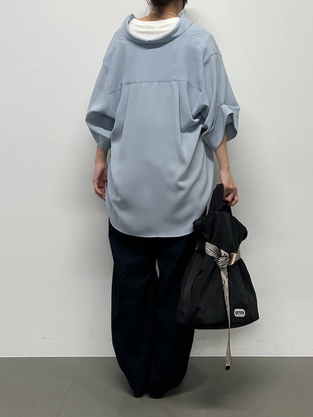 ブルー系のシャツ/ブラウス、ブラック系のパンプス、ブラック系のトートバッグを着用したレディースの春コーディネートの3枚目の写真