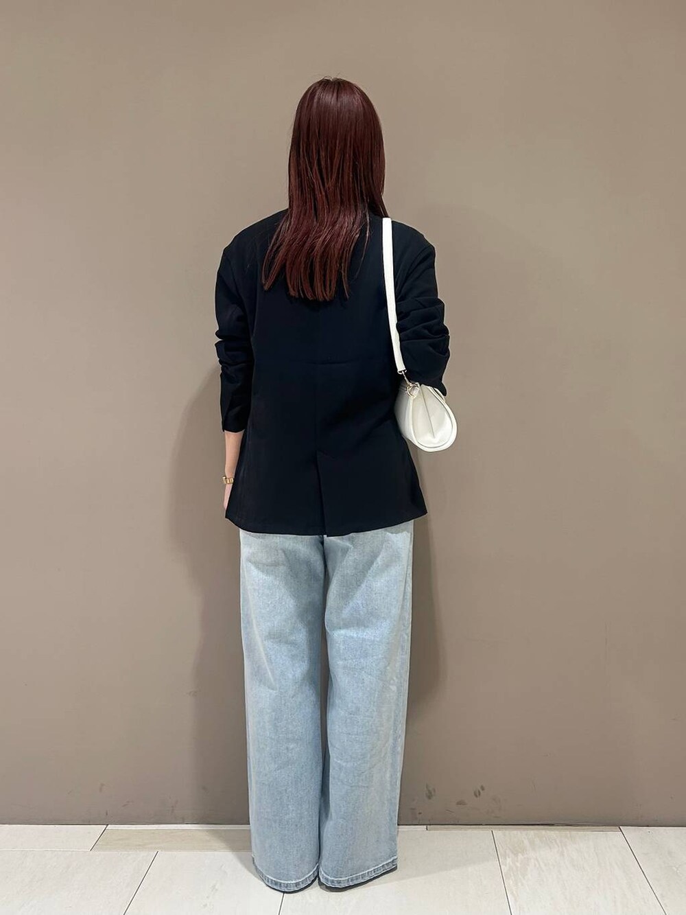 シルバー系のローファー、ブルー系のデニムパンツ、ブラック系のテーラードジャケットを着用したレディースの冬コーディネートの3枚目の写真