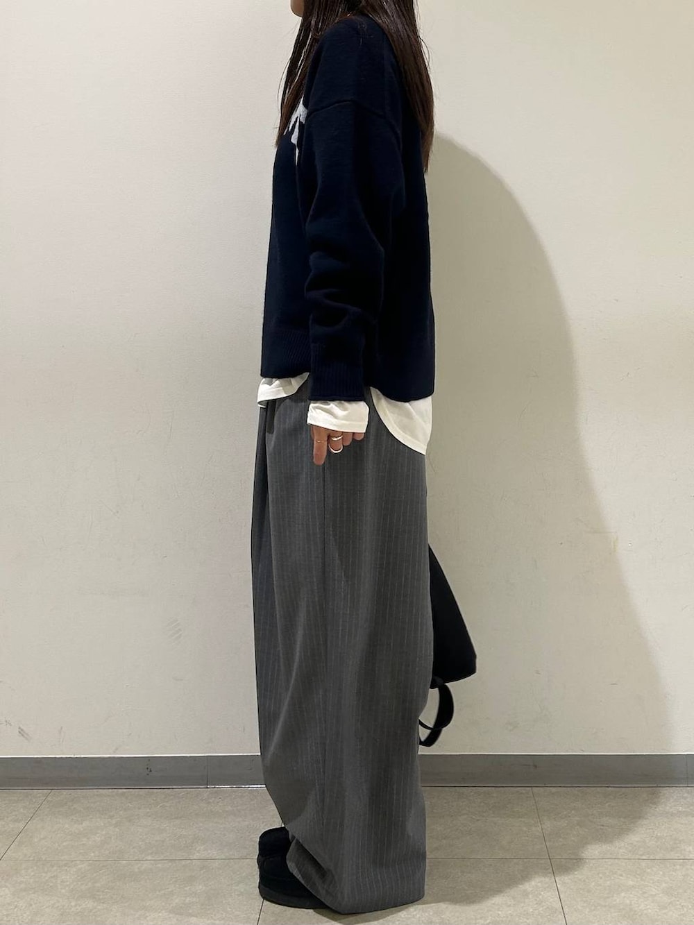 ブルー系のニット/セーター、グレー系のその他パンツ、ブラック系のバックパック/リュックを着用したレディースの冬コーディネートの2枚目の写真