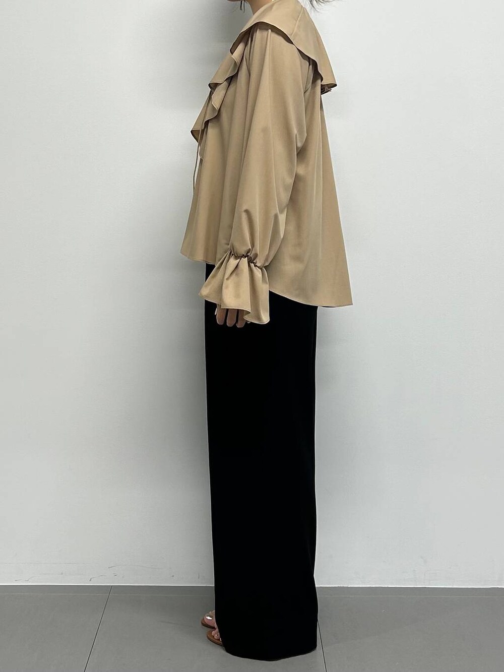 ブラック系のショルダーバッグ、ブラック系のスラックス、ブラウン系のサンダルを着用したレディースの夏コーディネートの2枚目の写真