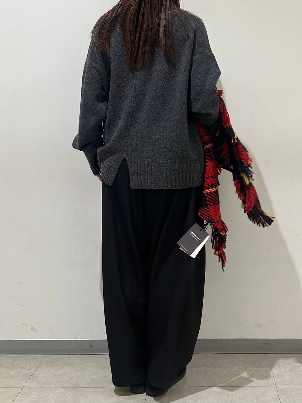 グレー系のニット/セーター、ブラック系のその他パンツ、レッド系のストール/ショールを着用したレディースの冬コーディネートの3枚目の写真