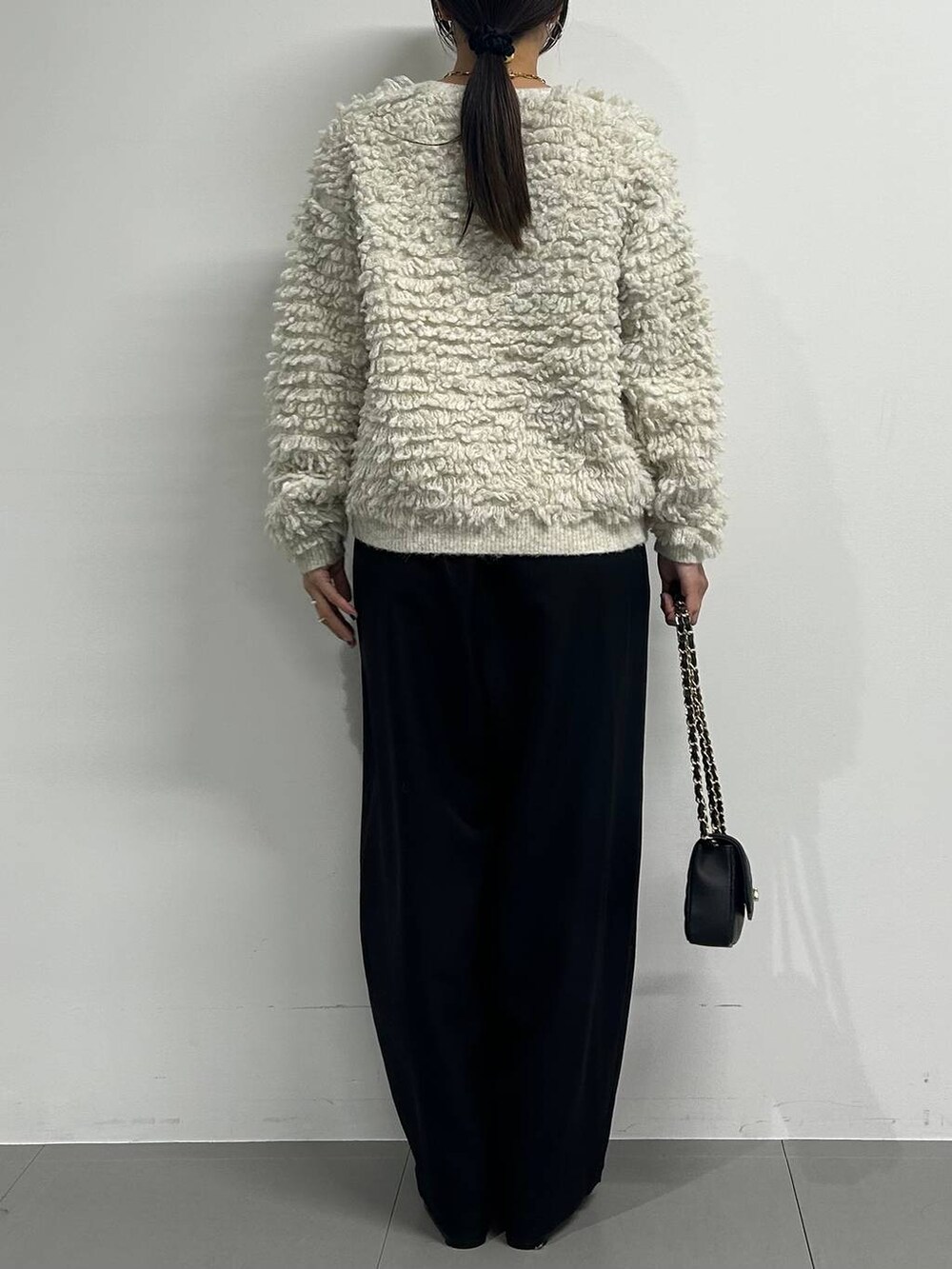 ブラック系のブーツ、ブラック系のその他パンツ、ホワイト系のカーディガン/ボレロを着用したレディースの冬コーディネートの3枚目の写真