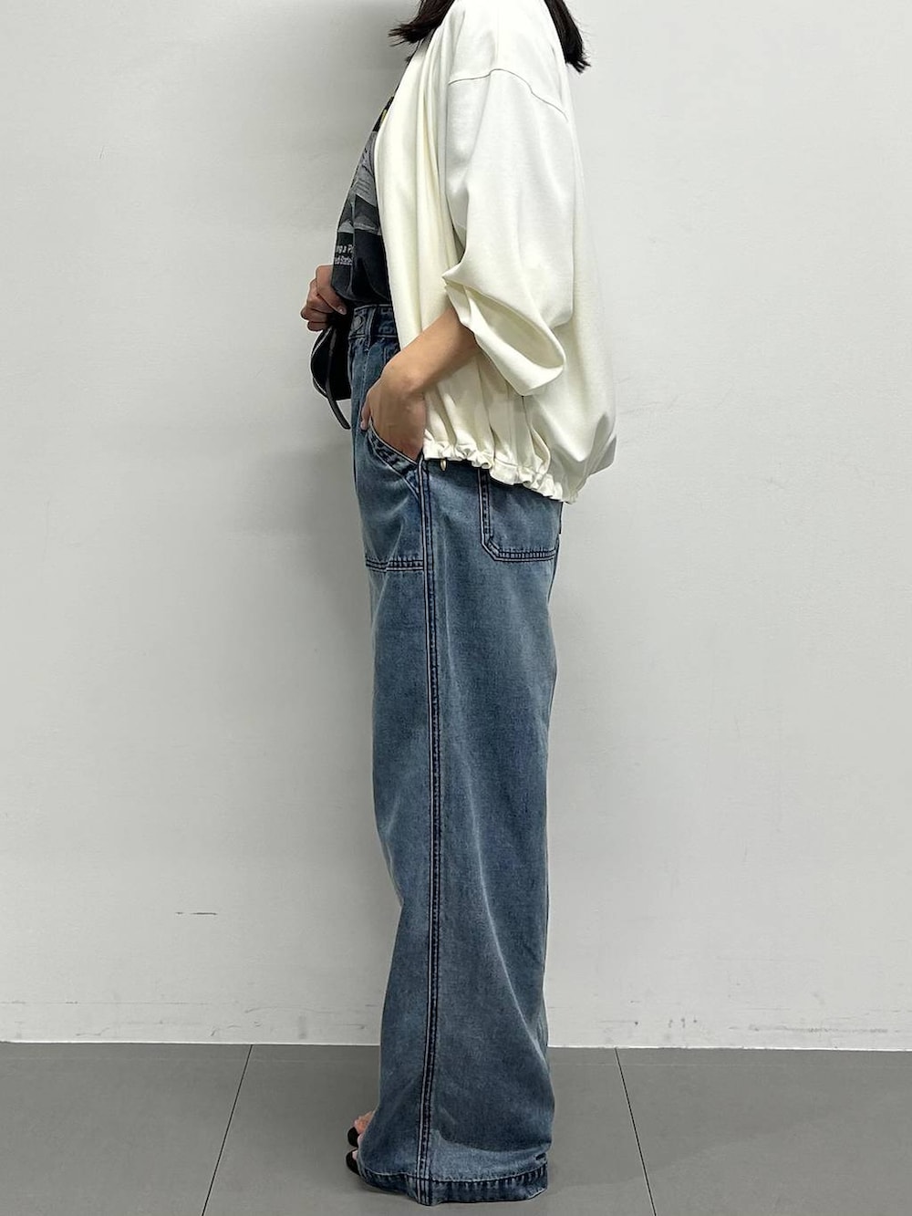 ホワイト系のブルゾン、ブルー系のデニムパンツ、グレー系のTシャツ/カットソーを着用したレディースの春コーディネートの2枚目の写真