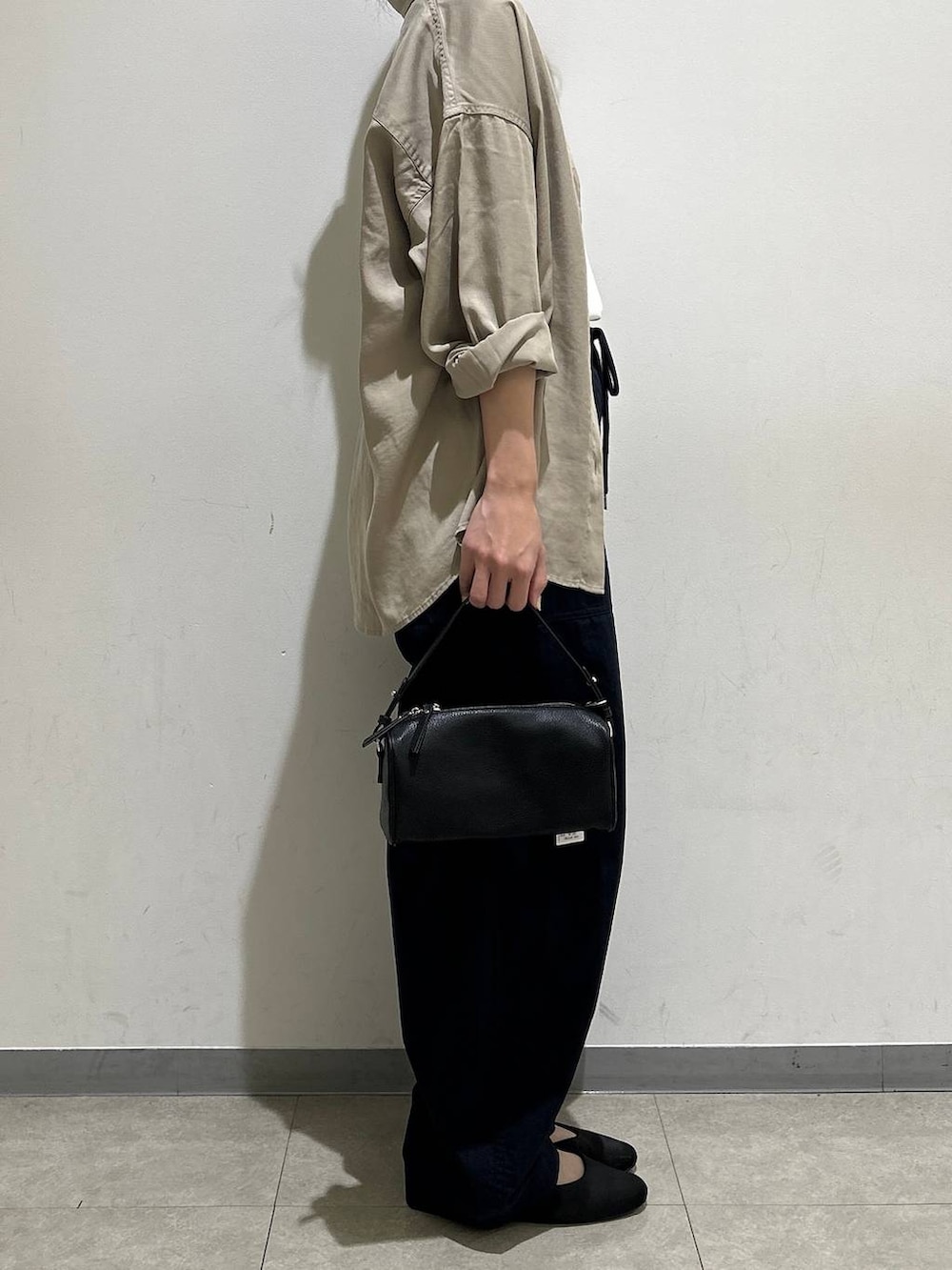 ブラック系のハンドバッグ、ホワイト系のTシャツ/カットソー、ブルー系のカーゴパンツを着用したレディースの夏コーディネートの2枚目の写真
