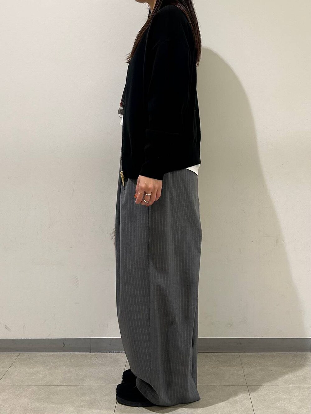 ブラウン系のトートバッグ、ブラック系のカーディガン/ボレロ、グレー系のその他パンツを着用したレディースの冬コーディネートの2枚目の写真