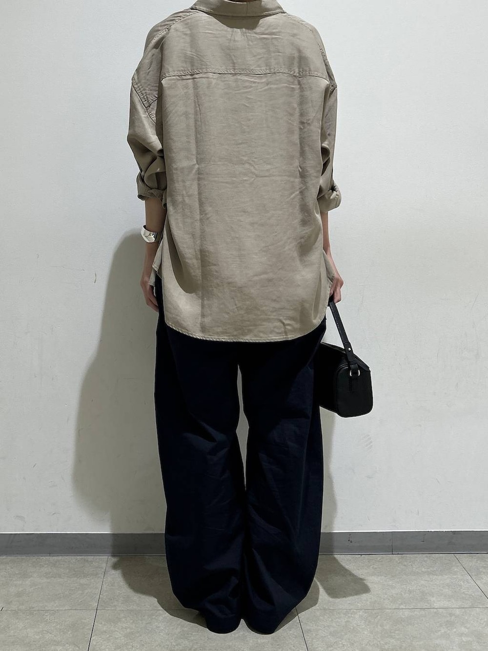 ブラック系のハンドバッグ、ホワイト系のTシャツ/カットソー、ブルー系のカーゴパンツを着用したレディースの夏コーディネートの3枚目の写真