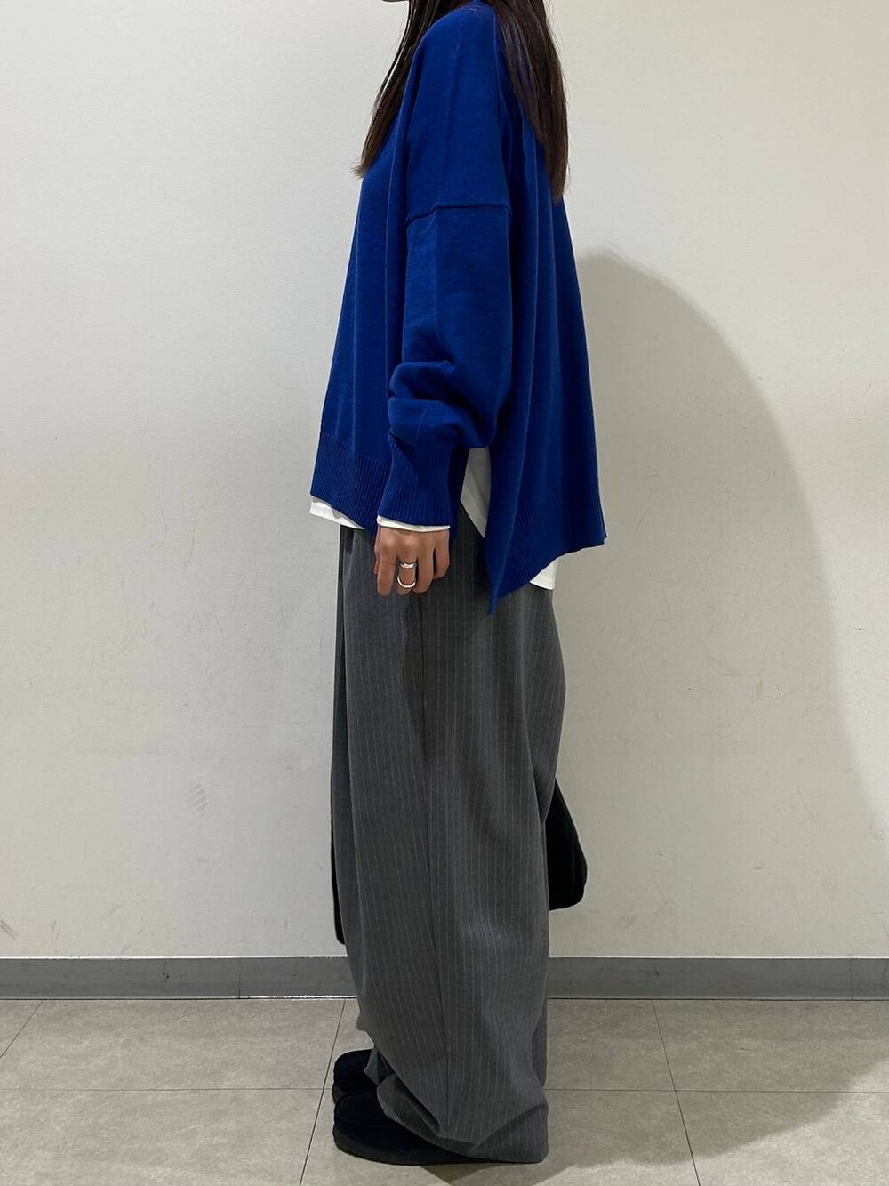 ホワイト系のTシャツ/カットソー、ブルー系のニット/セーター、グレー系のその他パンツを着用したレディースの冬コーディネートの2枚目の写真