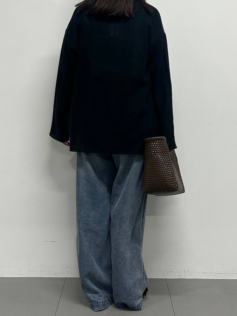 ブルー系のデニムパンツ、ブラック系のサンダルを着用したレディースの春コーディネートの3枚目の写真