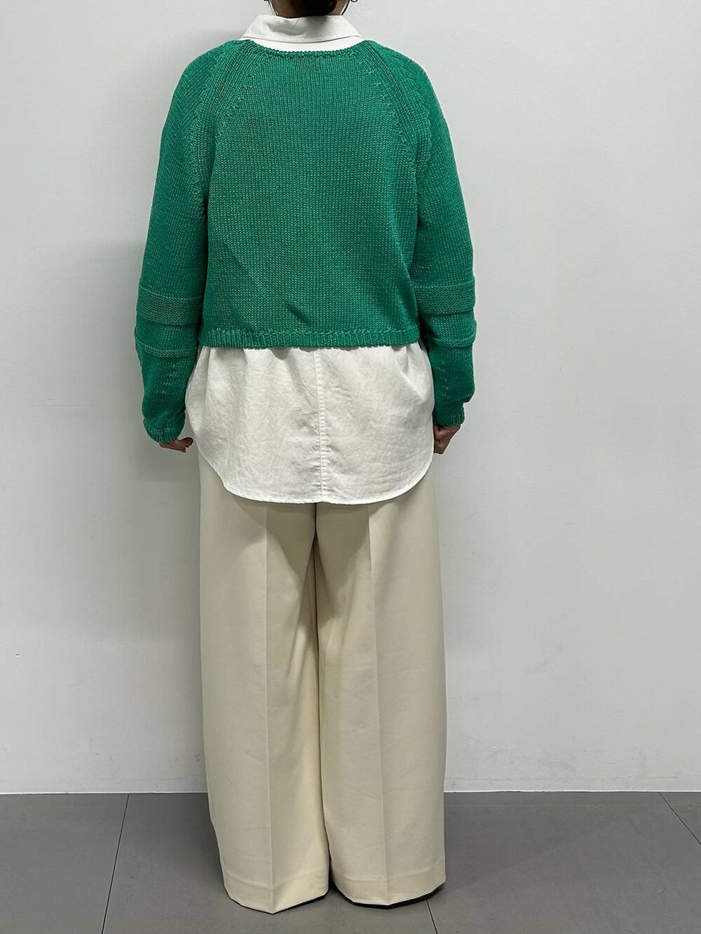 グリーン系のニット/セーター、ホワイト系のシャツ/ブラウス、ブラウン系のパンプスを着用したレディースの冬コーディネートの3枚目の写真