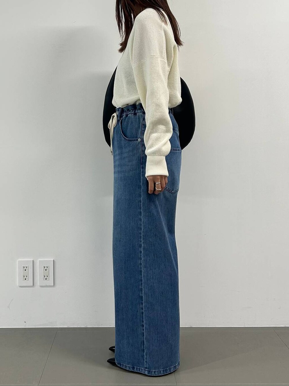 ブルー系のデニムパンツを着用したレディースの冬コーディネートの2枚目の写真