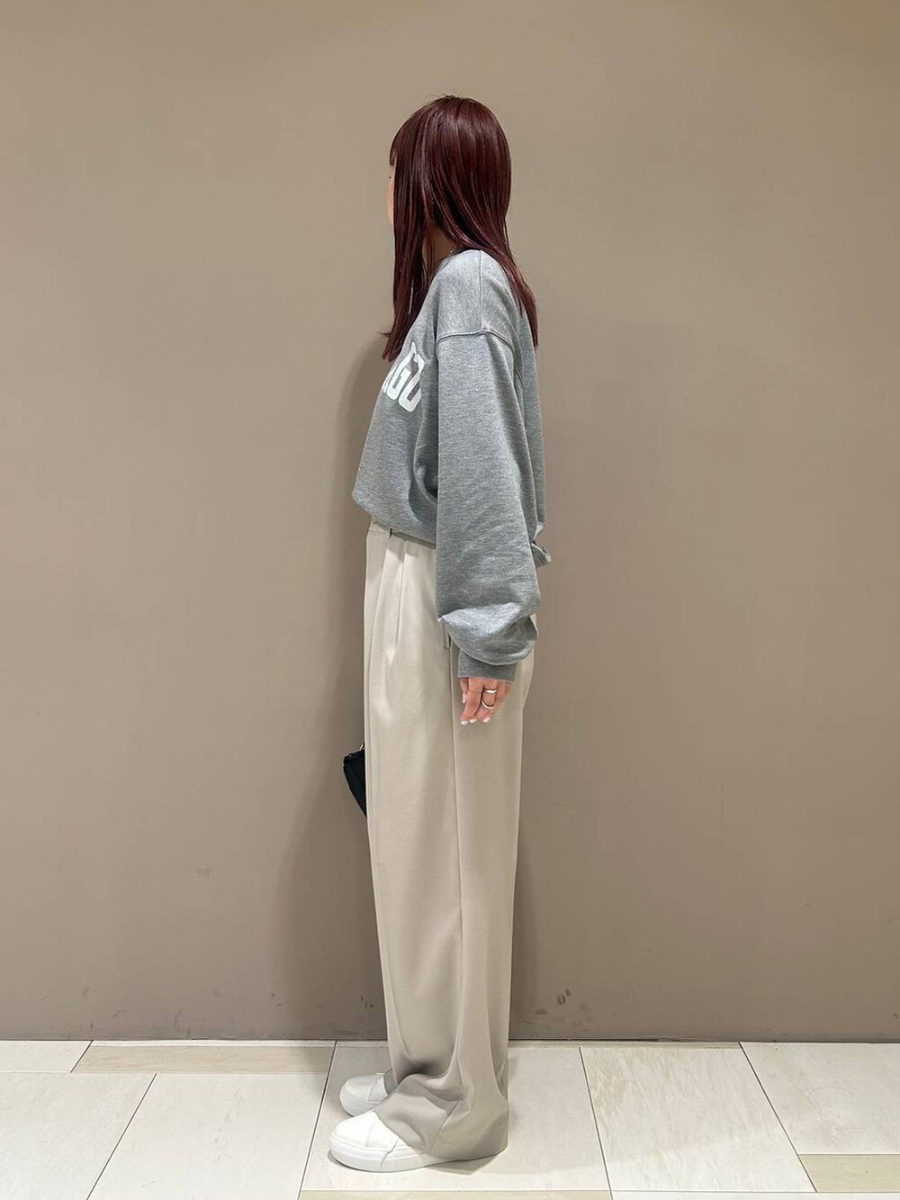 ブラック系のボディバッグ/ウエストポーチ、ホワイト系のスニーカー、ベージュ系のスラックスを着用したレディースの冬コーディネートの3枚目の写真