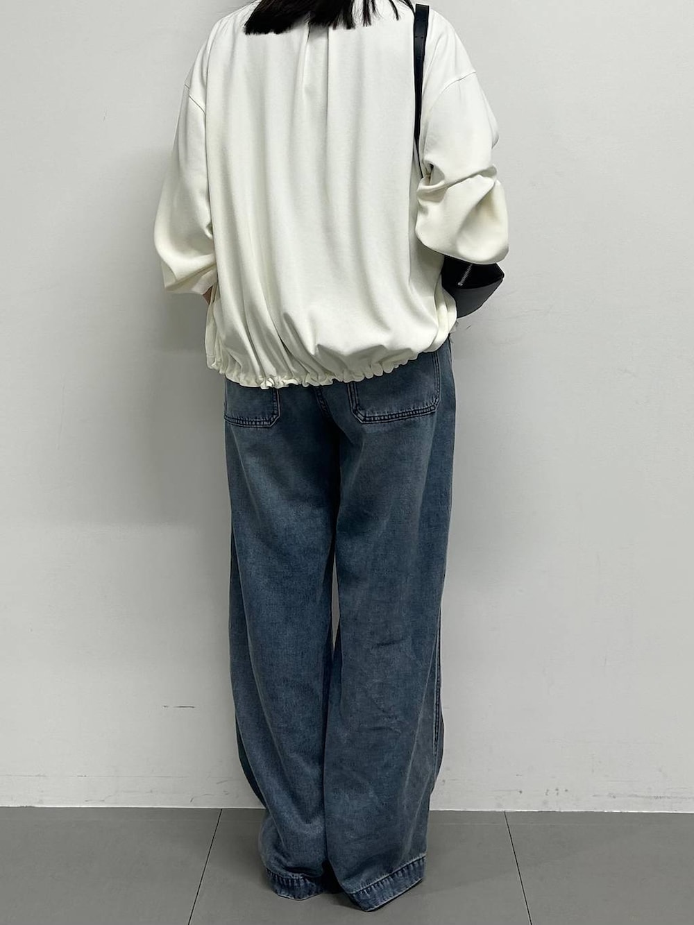 ホワイト系のブルゾン、ブルー系のデニムパンツ、グレー系のTシャツ/カットソーを着用したレディースの春コーディネートの3枚目の写真