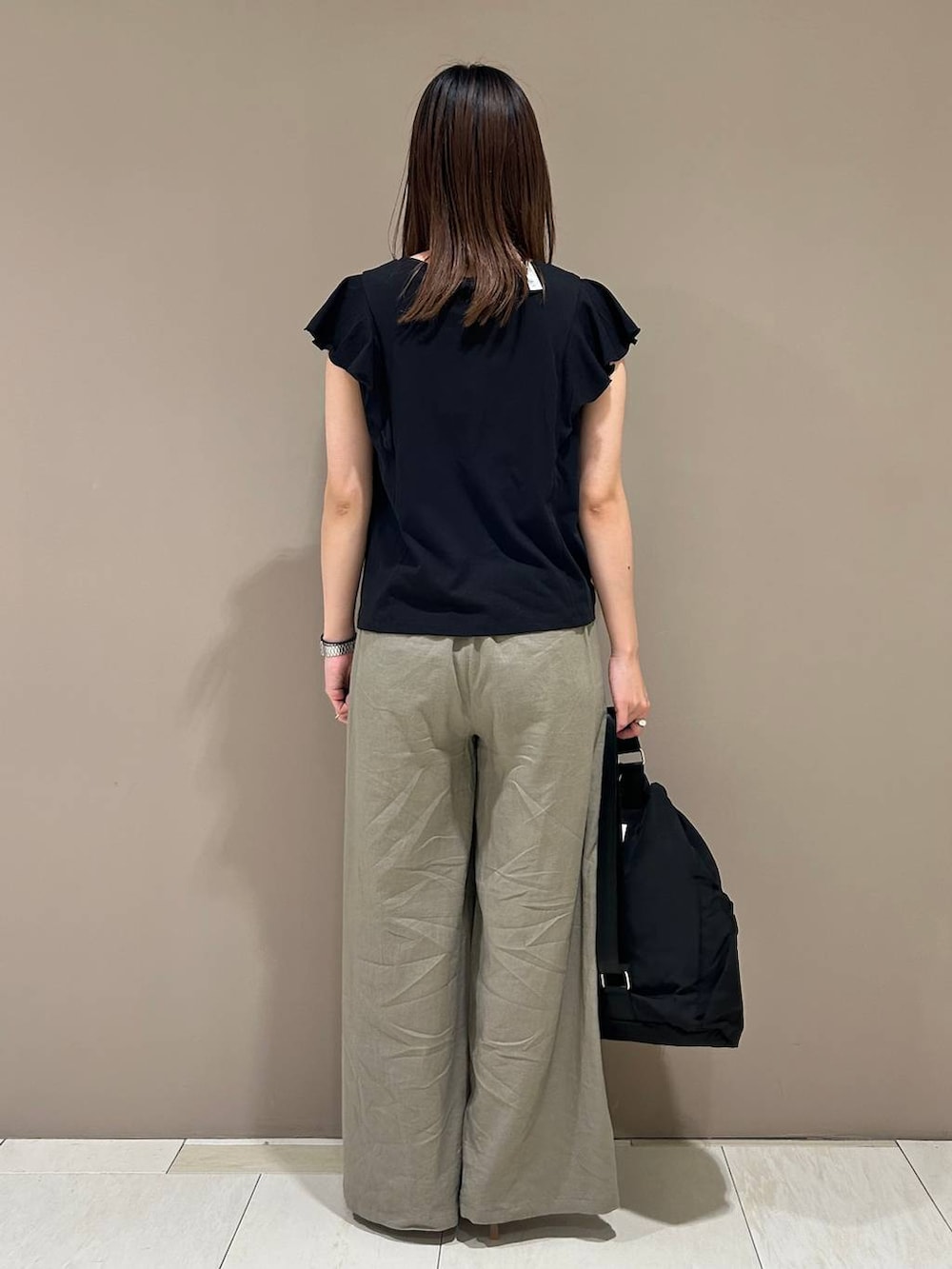 ベージュ系のスリッポン、ブラウン系のその他パンツ、ブラック系のバックパック/リュックを着用したレディースの夏コーディネートの3枚目の写真