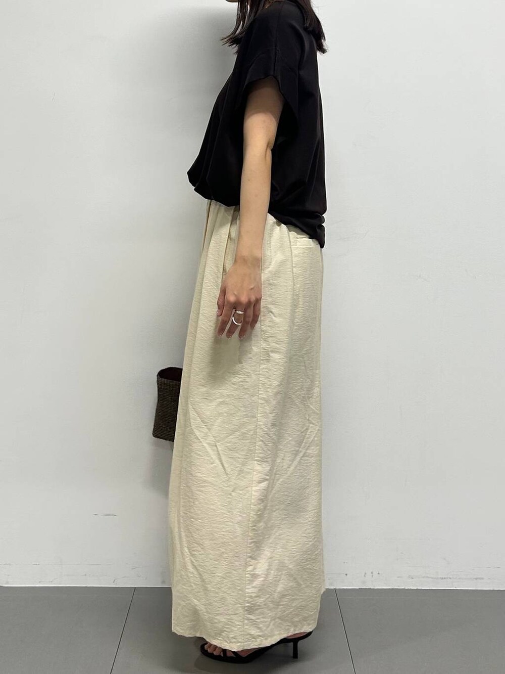 ホワイト系のその他パンツ、ブラック系のサンダル、ブラック系のかごバッグを着用したレディースの春コーディネートの2枚目の写真