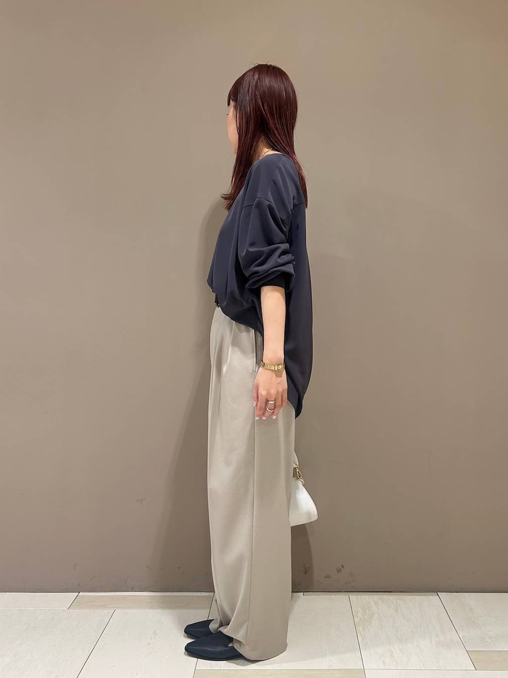 ブルー系のローファー、ホワイト系のショルダーバッグ、グレー系のシャツ/ブラウスを着用したレディースの冬コーディネートの2枚目の写真