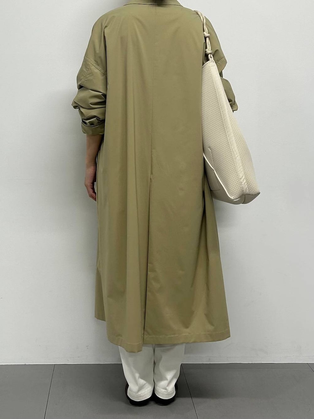 イエロー系のニット/セーター、ホワイト系のカーゴパンツ、ブラウン系のパンプスを着用したレディースの冬コーディネートの3枚目の写真