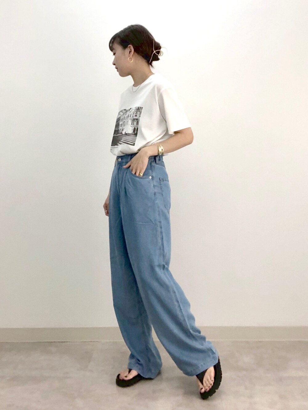 ホワイト系のTシャツ/カットソー、ブルー系のデニムパンツ、ブラック系のシューズを着用したレディースの夏コーディネートの2枚目の写真