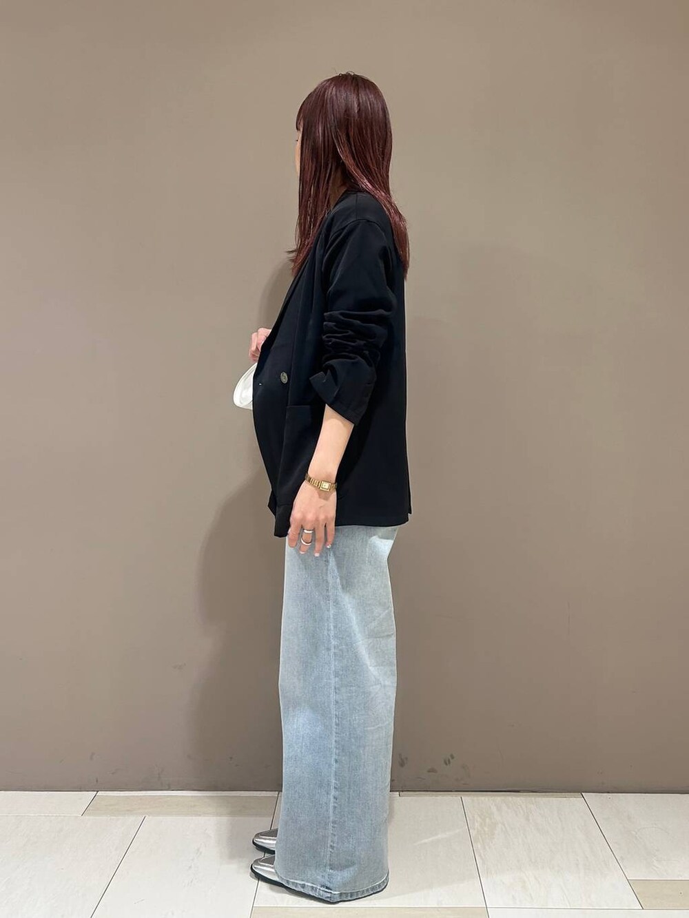 シルバー系のローファー、ブルー系のデニムパンツ、ブラック系のテーラードジャケットを着用したレディースの冬コーディネートの2枚目の写真