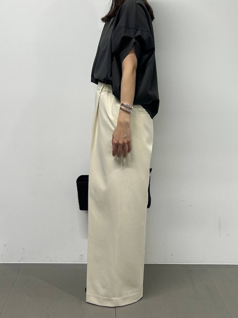 グレー系のTシャツ/カットソー、ホワイト系のその他パンツ、ブラック系のサンダルを着用したレディースの春コーディネートの2枚目の写真