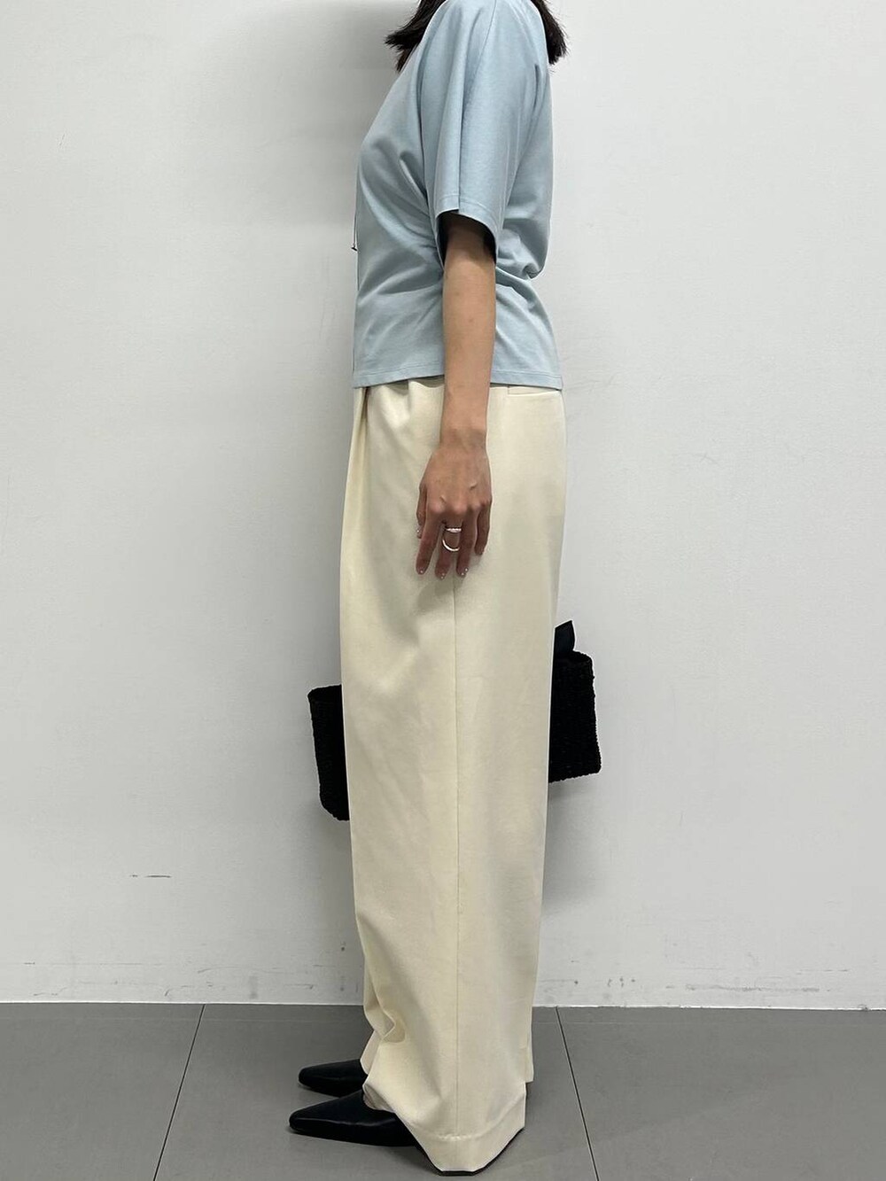 ブラック系のパンプス、ホワイト系のその他パンツ、ブラック系のかごバッグを着用したレディースの春コーディネートの2枚目の写真