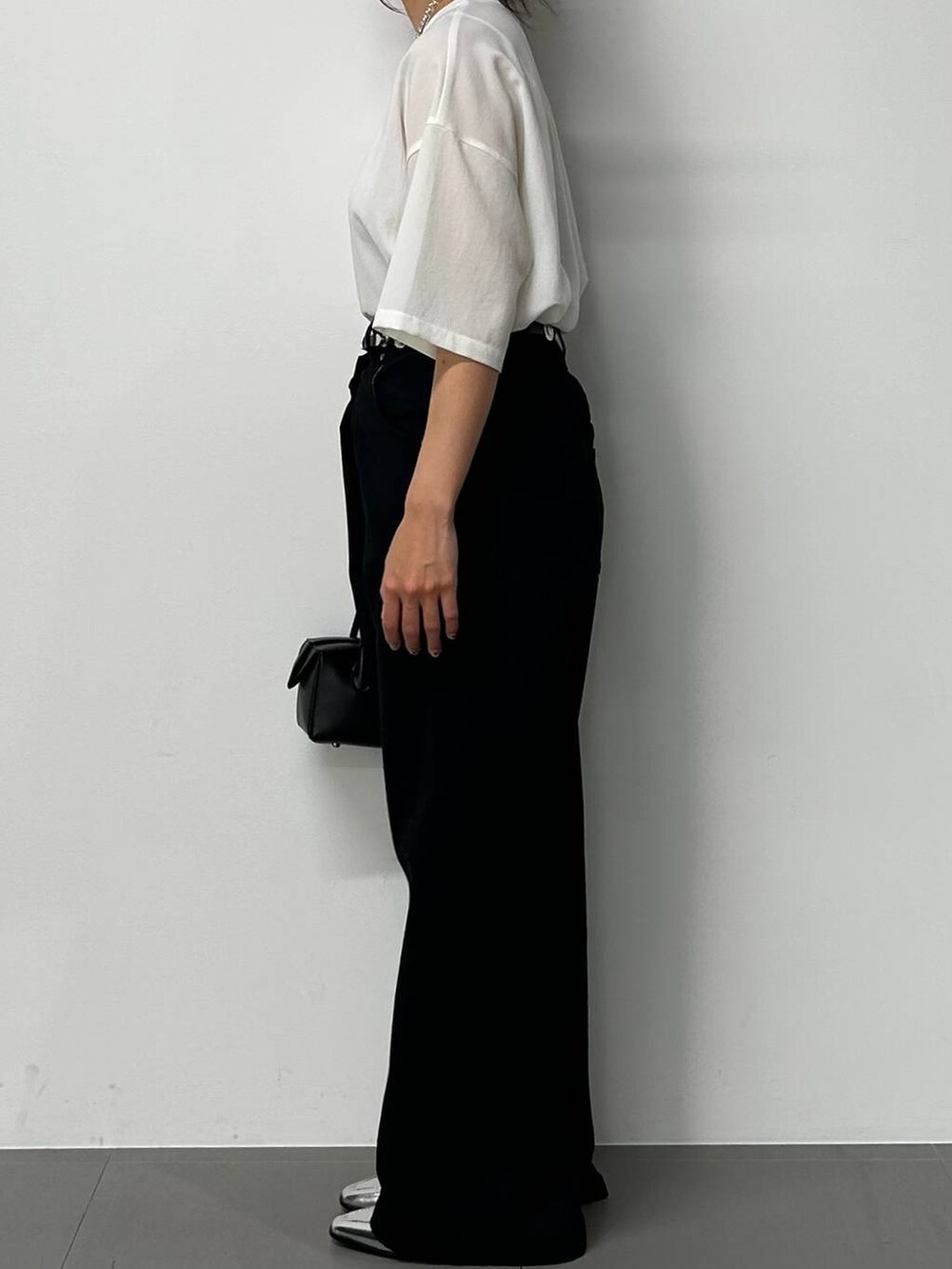 シルバー系のローファー、ホワイト系のシャツ/ブラウス、ブラック系のハンドバッグを着用したレディースの夏コーディネートの2枚目の写真