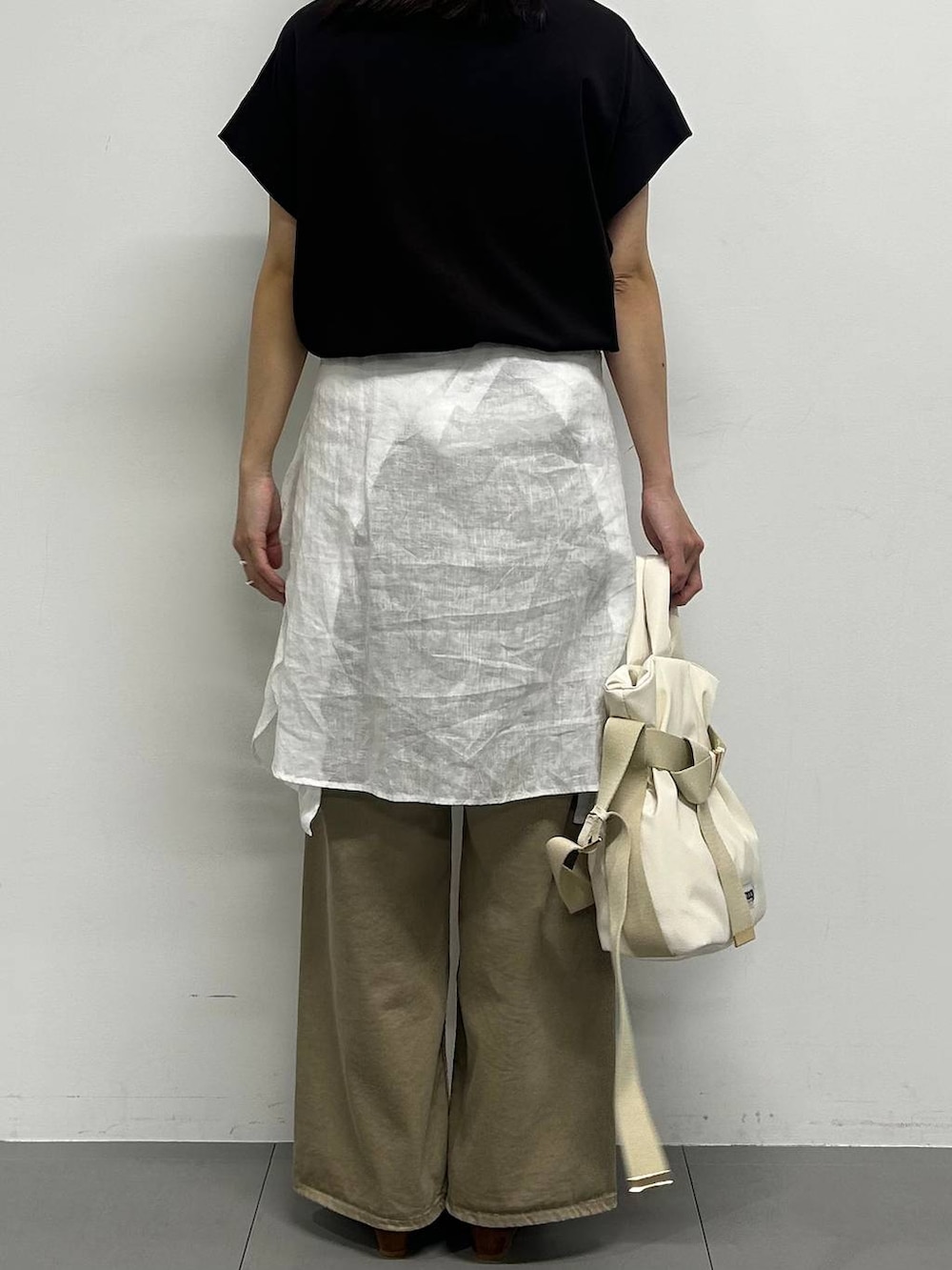 ホワイト系のシャツ/ブラウス、ブラック系のTシャツ/カットソー、イエロー系のパンプスを着用したレディースの春コーディネートの3枚目の写真