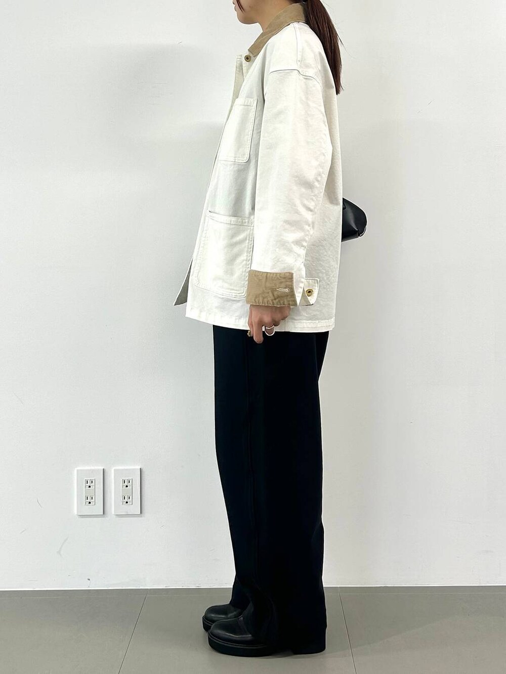 ブラック系のショルダーバッグを着用したレディースの冬コーディネートの2枚目の写真