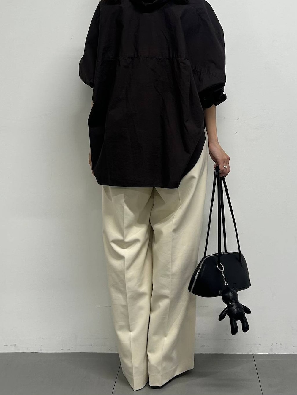 ブラウン系のシャツ/ブラウス、ブラック系のハンドバッグ、ホワイト系のその他パンツを着用したレディースの春コーディネートの3枚目の写真