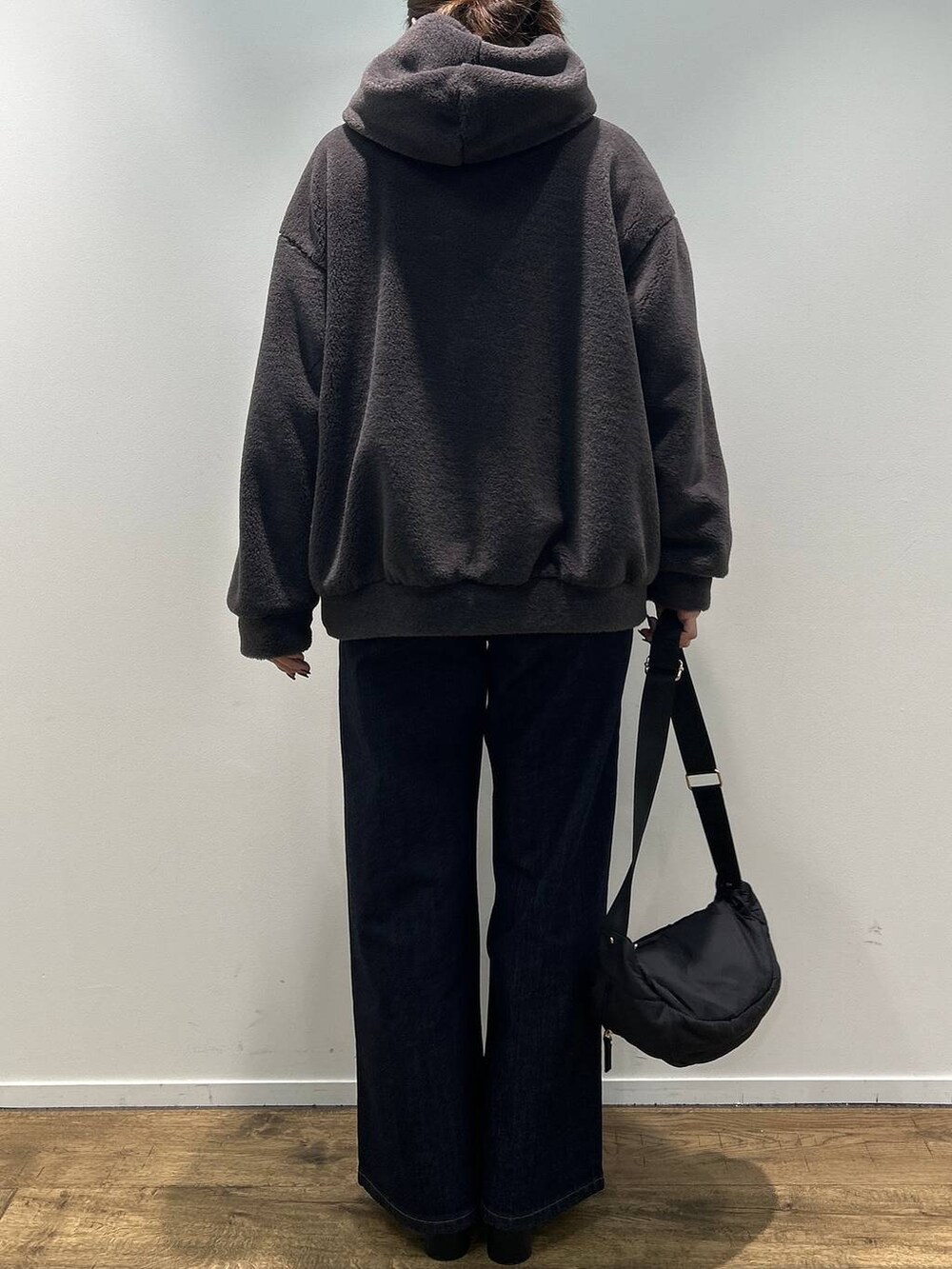 グレー系のブルゾン、ブラック系のブーツ、ブルー系のデニムパンツを着用したレディースの秋コーディネートの3枚目の写真