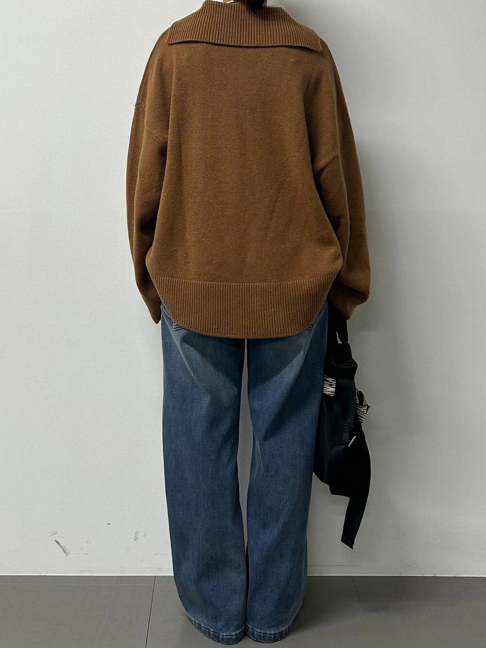 ブルー系のデニムパンツ、イエロー系のニット/セーター、その他のショルダーバッグを着用したレディースの秋コーディネートの3枚目の写真