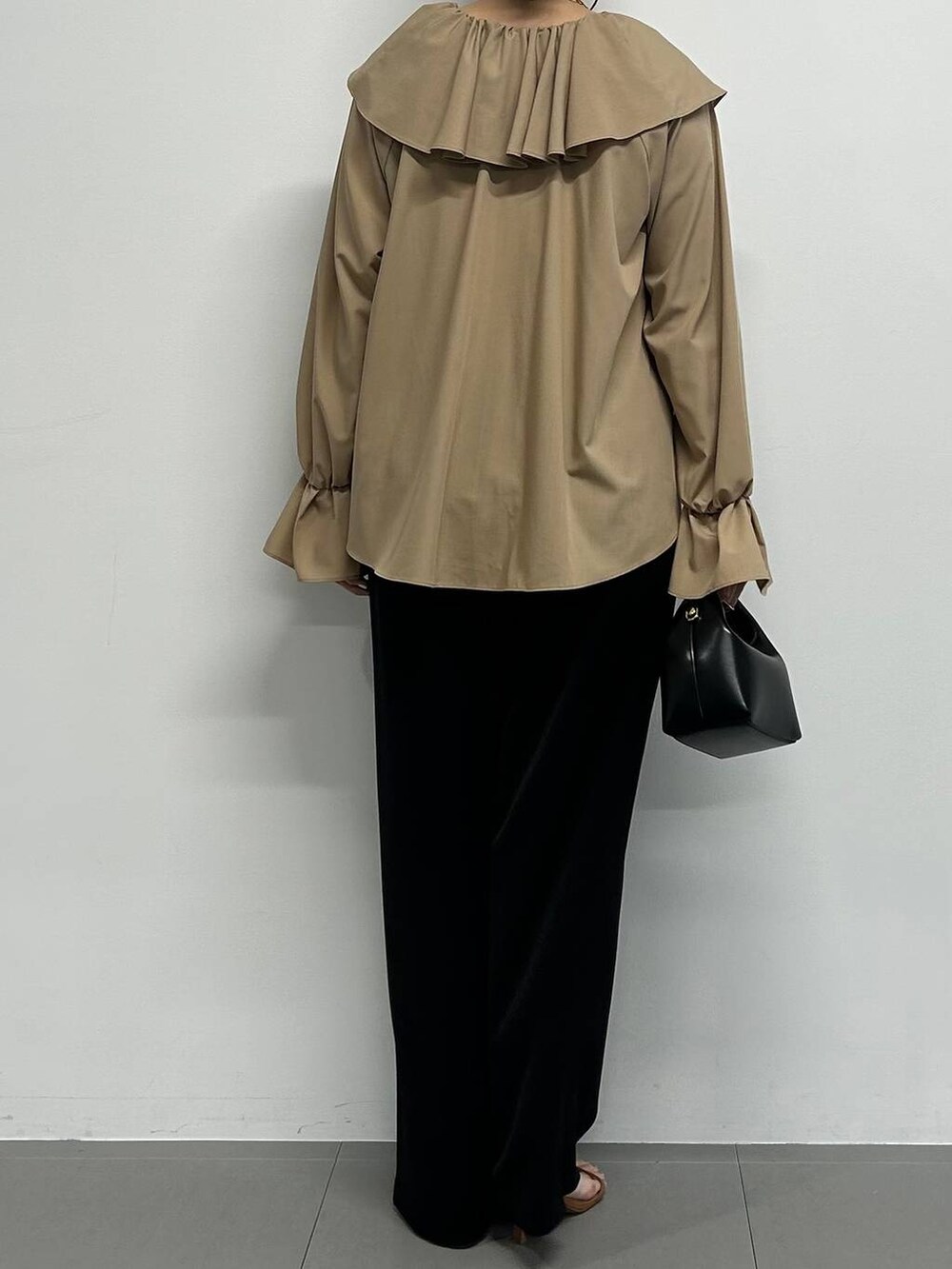 ブラック系のショルダーバッグ、ブラック系のスラックス、ブラウン系のサンダルを着用したレディースの夏コーディネートの3枚目の写真