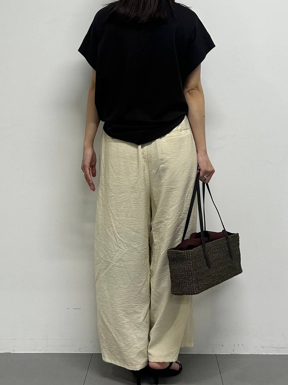 ホワイト系のその他パンツ、ブラック系のサンダル、ブラック系のかごバッグを着用したレディースの春コーディネートの3枚目の写真