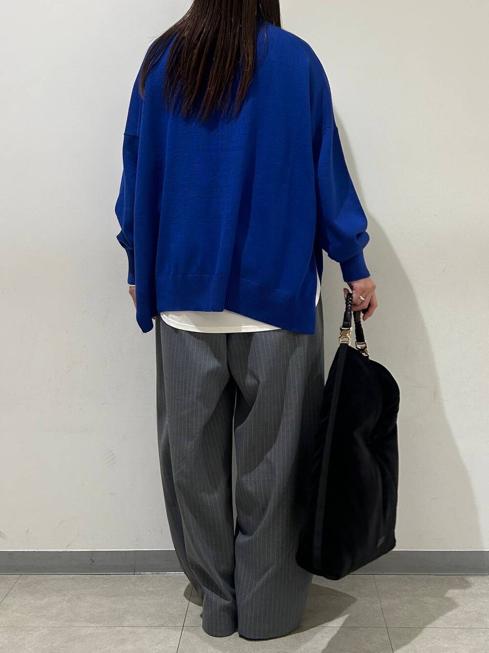 ホワイト系のTシャツ/カットソー、ブルー系のニット/セーター、グレー系のその他パンツを着用したレディースの冬コーディネートの3枚目の写真