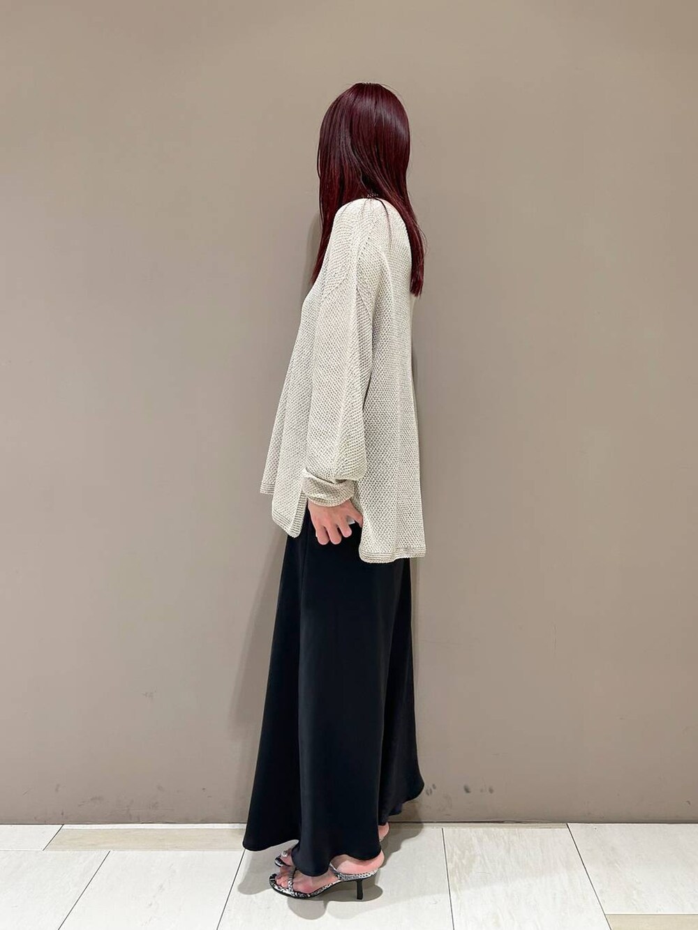 ホワイト系のハンドバッグ、ベージュ系のニット/セーター、その他のサンダルを着用したレディースの春コーディネートの2枚目の写真