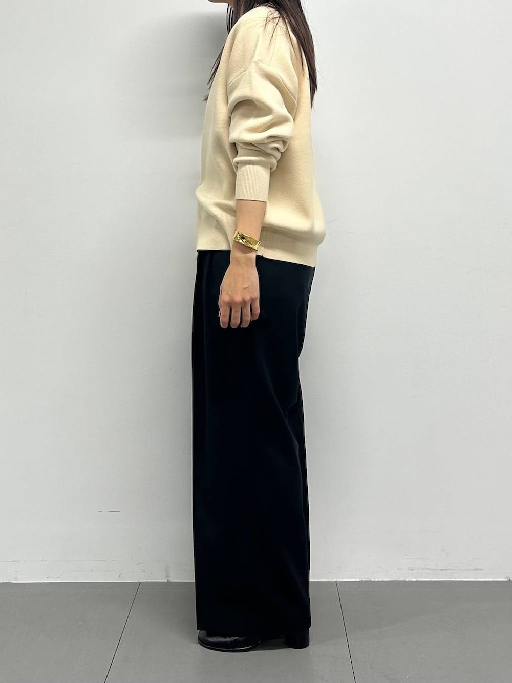 ホワイト系のカーディガン/ボレロ、ブラック系のスラックス、ゴールド系のチョーカーを着用したレディースの冬コーディネートの2枚目の写真