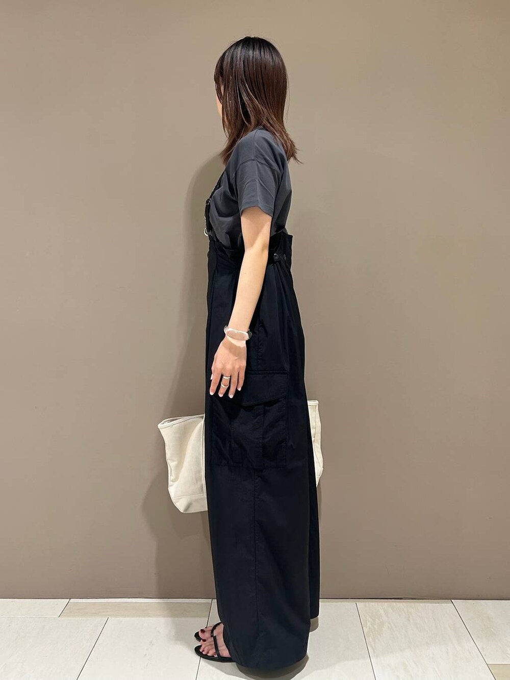 ブラック系のスリッポン、グレー系のTシャツ/カットソー、ホワイト系のトートバッグを着用したレディースの夏コーディネートの2枚目の写真