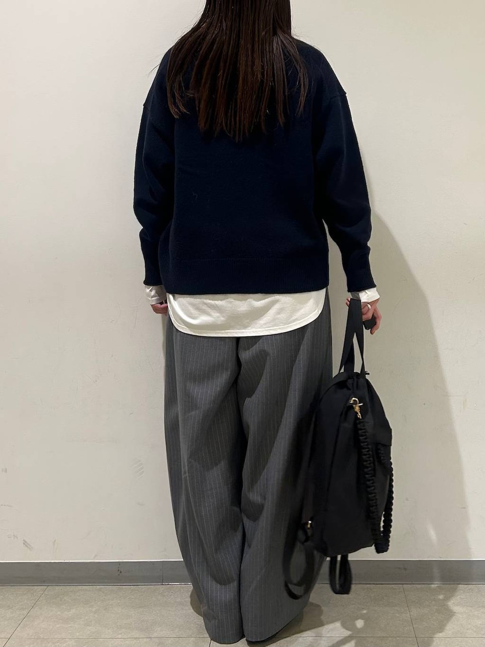 ブルー系のニット/セーター、グレー系のその他パンツ、ブラック系のバックパック/リュックを着用したレディースの冬コーディネートの3枚目の写真