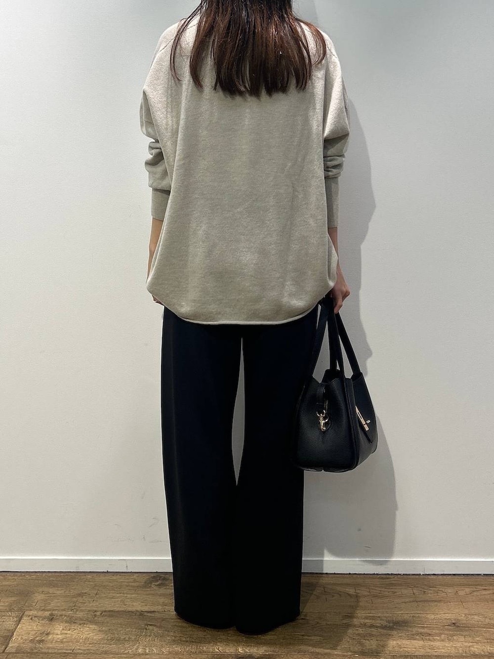 ブラック系のハンドバッグ、ブラック系のその他パンツ、ホワイト系のニット/セーターを着用したレディースの秋コーディネートの3枚目の写真