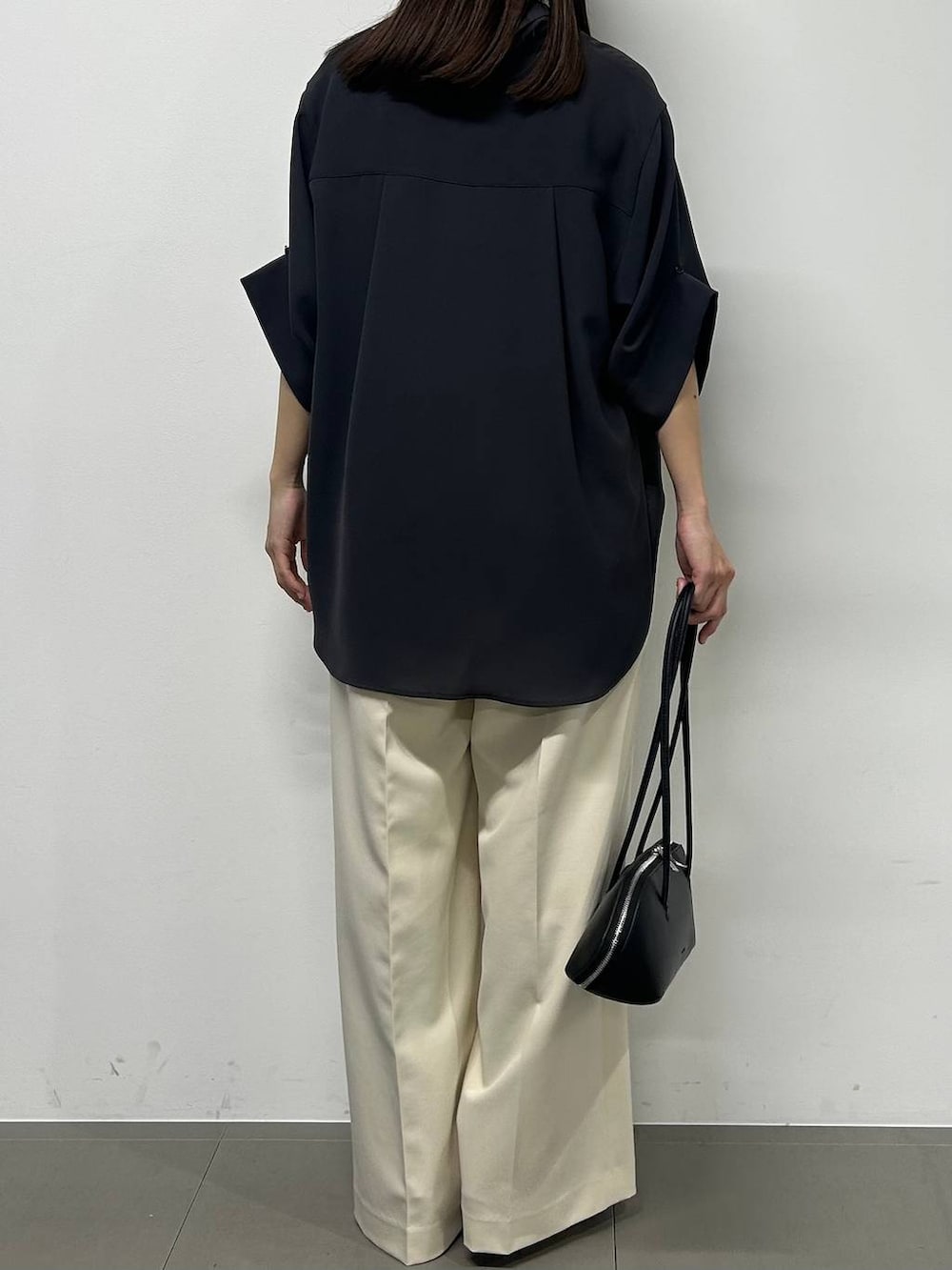 ブラック系のハンドバッグ、グレー系のシャツ/ブラウス、ホワイト系のその他パンツを着用したレディースの春コーディネートの3枚目の写真