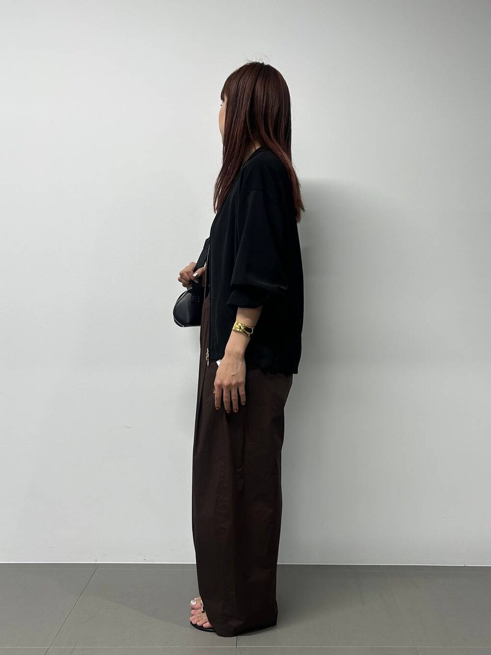 ブラック系のショルダーバッグ、ブラック系のブルゾン、その他のネックレスを着用したレディースの春コーディネートの2枚目の写真