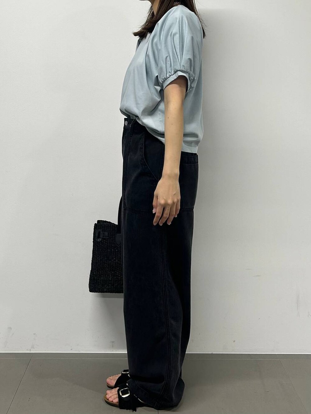 グレー系のデニムパンツ、ブラック系のかごバッグ、ブラック系のサンダルを着用したレディースの春コーディネートの3枚目の写真