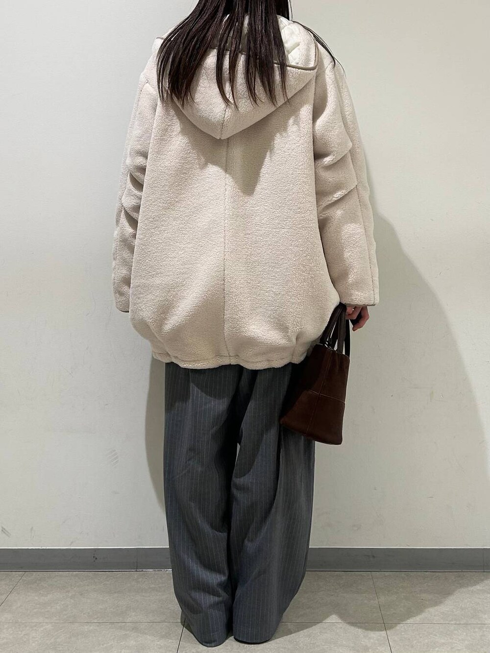 ホワイト系のその他アウター、グレー系のその他パンツ、ホワイト系のTシャツ/カットソーを着用したレディースの冬コーディネートの3枚目の写真