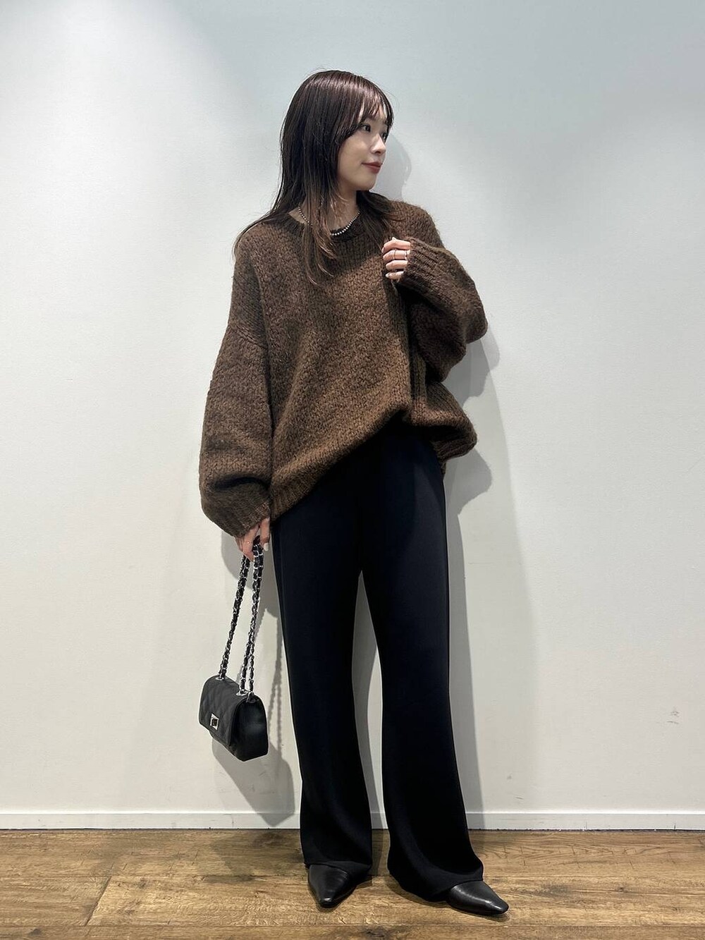 ブラック系のハンドバッグ、ブラウン系のニット/セーター、ブラック系のその他パンツを着用したレディースの秋コーディネートの2枚目の写真