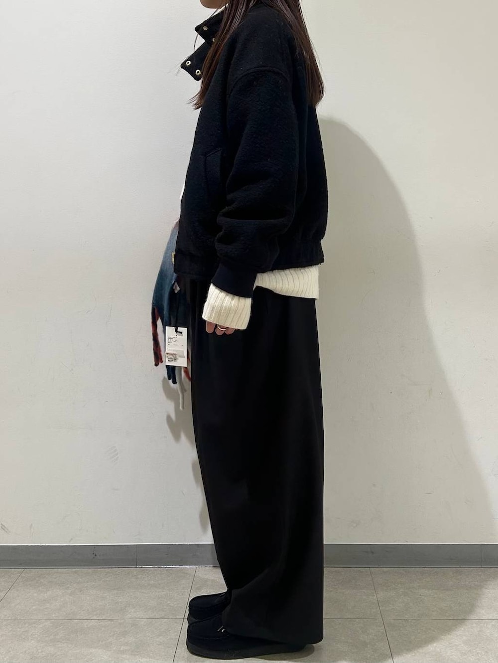 ブラック系のブルゾン、ホワイト系のニット/セーター、ブラック系のその他パンツを着用したレディースの冬コーディネートの2枚目の写真