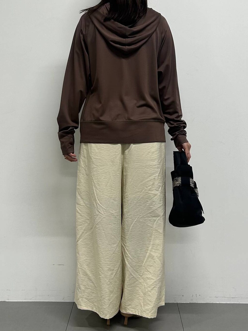 ホワイト系のその他パンツ、その他のショルダーバッグ、ブラウン系のパーカーを着用したレディースの春コーディネートの3枚目の写真