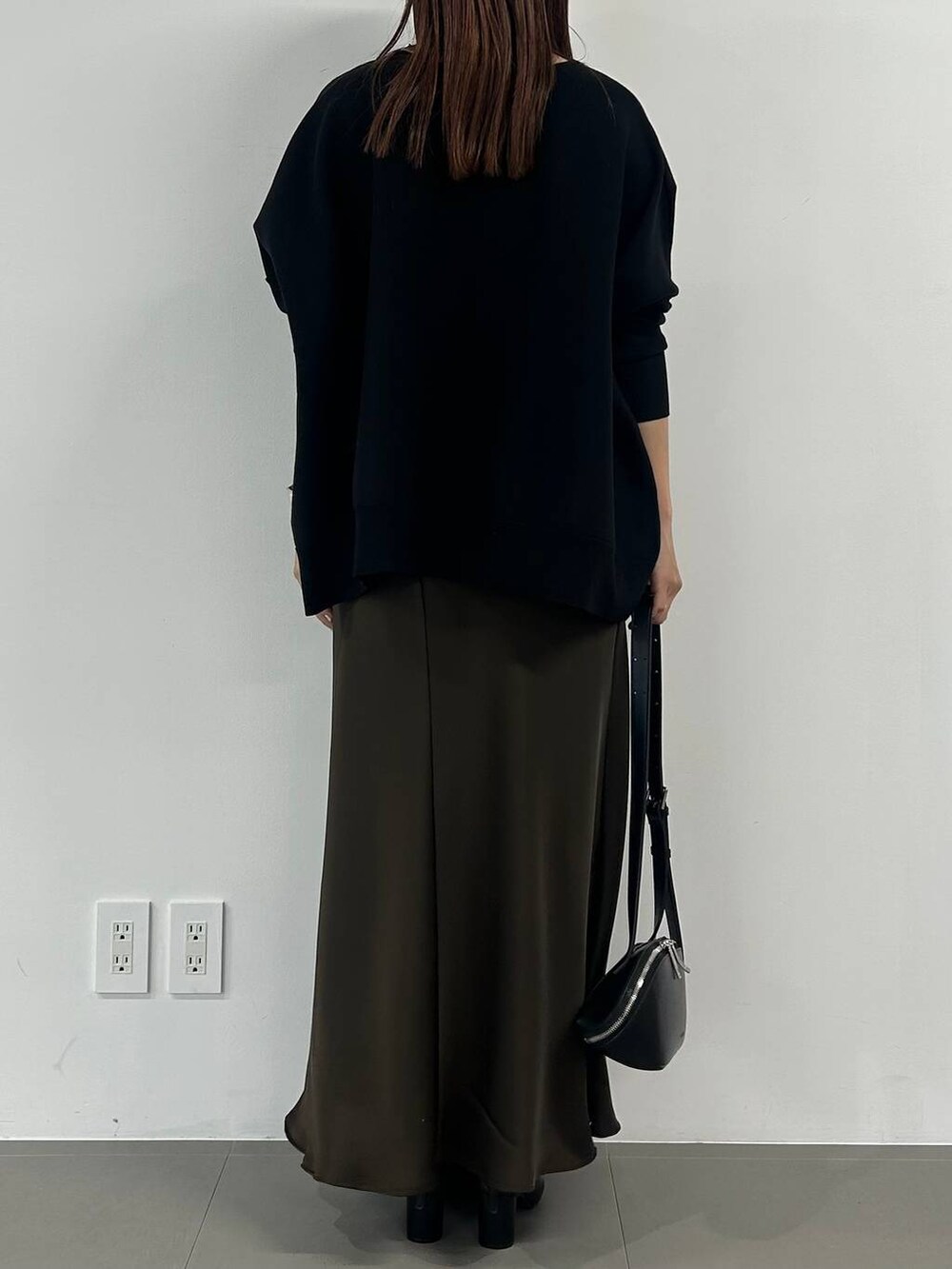 ブラック系のブーツ、ブラウン系のスカート、シルバー系のネックレスを着用したレディースの冬コーディネートの3枚目の写真